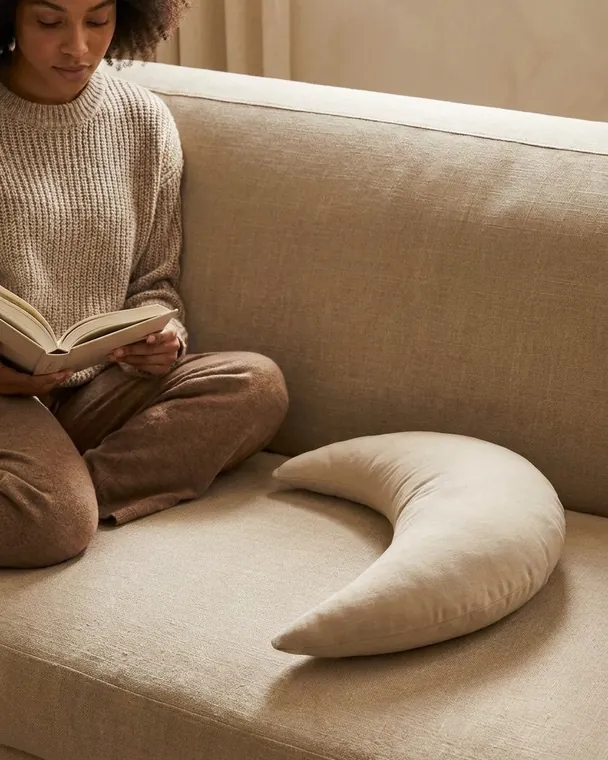 The Cove Mini on a linen sofa beside someone reading