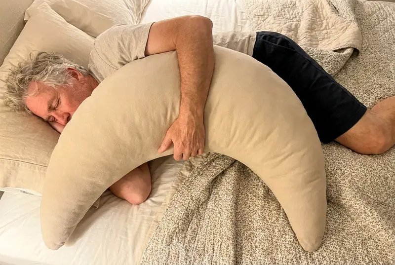 A young woman asleep with her arm over an Oat Cove