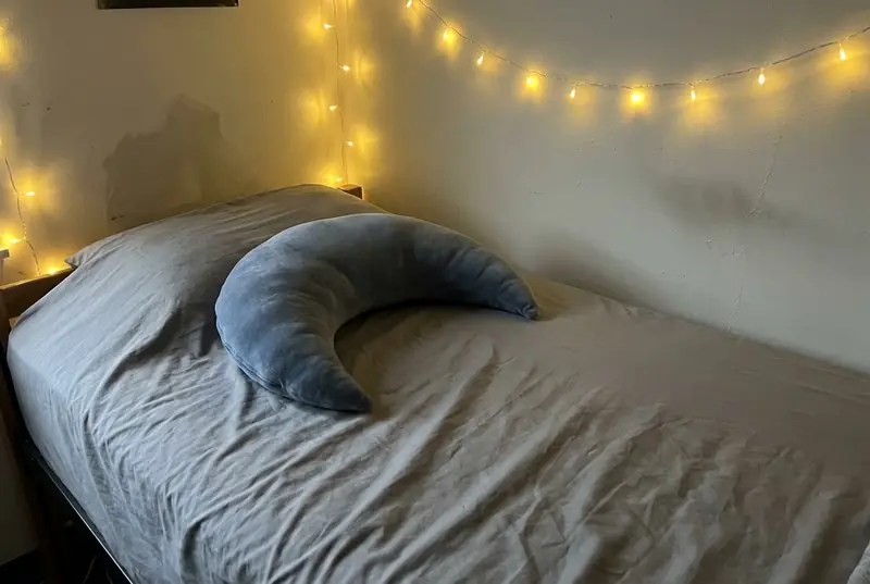 A Slate Cove Mini on a dorm twin bed under string lights